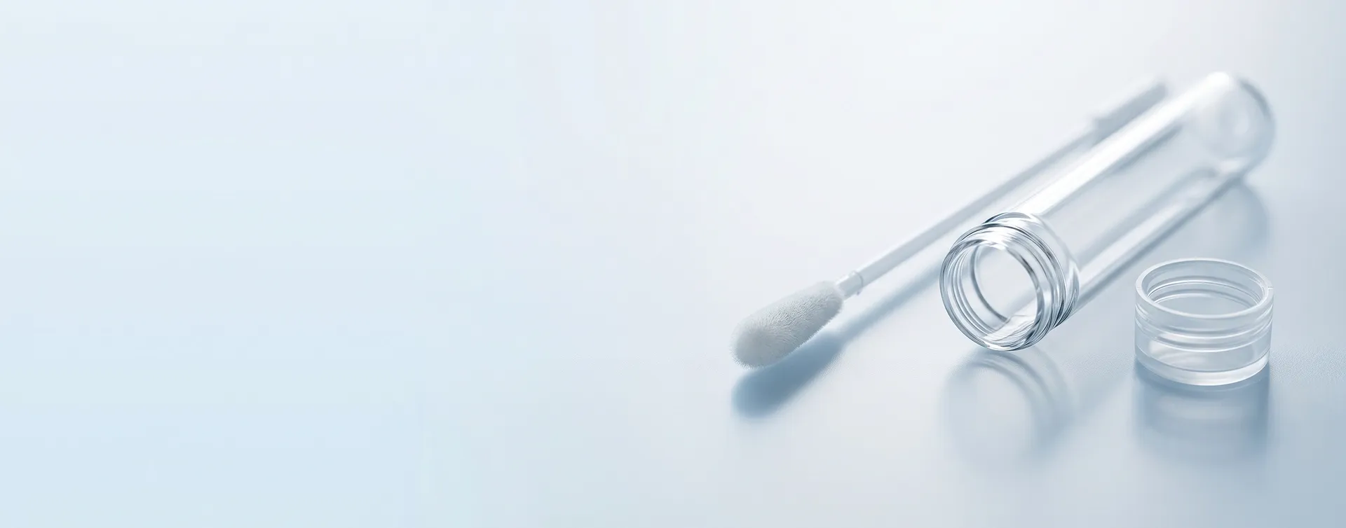 Abstrichtupfer neben geöffnetem Probenröhrchen für DNA- oder Speicheltest