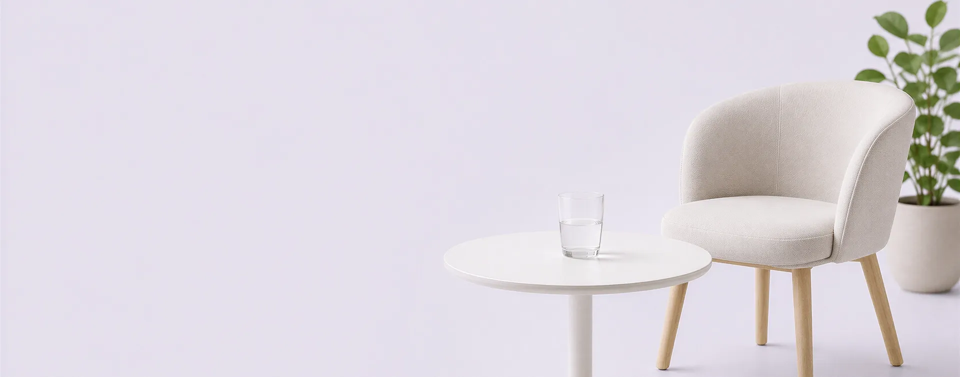 Gemütlicher Wartebereich mit Sessel, Beistelltisch, Wasserglas und Pflanze